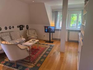 a living room with a couch and a tv at Doppelzimmer am Park in Bremerhaven +6 photos