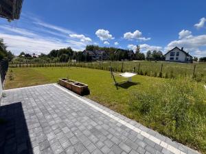 a backyard with a bench and a field of grass at LOG apartament in Dobrzewino