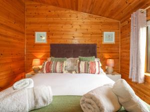 a bedroom with a bed in a wooden room at Derwent Lodge in Keswick