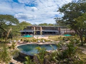 a resort with a swimming pool and a building at Waterfalls Lodge in Victoria Falls