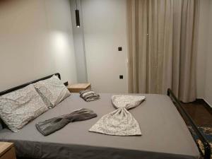 a bed with two pillows and towels on it at Britannia Apartments in Gjirokastër