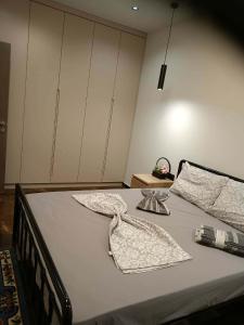 a bedroom with a bed with two towels on it at Britannia Apartments in Gjirokastër