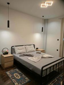 a bedroom with a large bed with aigiligiligil at Britannia Apartments in Gjirokastër