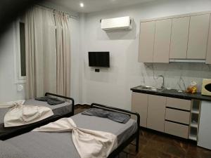 a room with two beds and a kitchen with a sink at Britannia Apartments in Gjirokastër