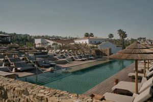 a swimming pool with lounge chairs and umbrellas at OKU Andalusia in La Alcaidesa