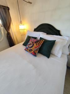 a white bed with two pillows on top of it at Chalé da sereia apart-hotel Oásis no centro de jericoacoara in Jericoacoara +70 photos
