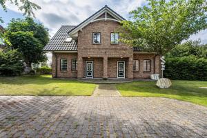 a brick house with a brick driveway at Haus Am Dorfteich B eingefriedet in Fehmarn