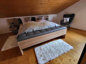 ein Schlafzimmer mit einem großen Bett und einem Stuhl in der Unterkunft Waldglanz Loft in Freyung + 18 Fotos