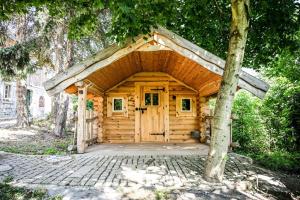 a log cabin with a wooden door and a tree at Berghof Papstdorf in Kurort Gohrisch