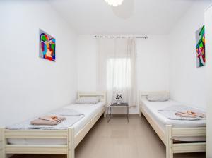 two beds in a room with white walls at Apartments Mia Patria in Ulcinj