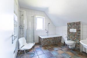 a bathroom with a tub and a toilet and a sink at Carpe Diem in Wieck +26 photos