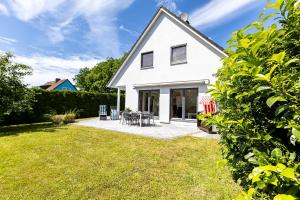 a white house with a patio and lawn at Carpe Diem in Wieck