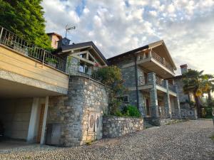 a large stone building with two balconies on it at Chalet al Lac - Cuori - Swimming Pool Como Lake View in Consiglio di Rumo