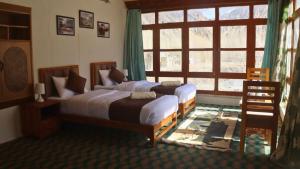 a bedroom with two beds and a large window at Wanla Eco Residence in Tarklak