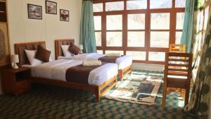 a bedroom with two beds and a large window at Wanla Eco Residence in Tarklak