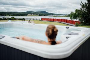 a dog sitting in a bath tub overlooking a river at Grand Arctic Resort in Överkalix +39 photos