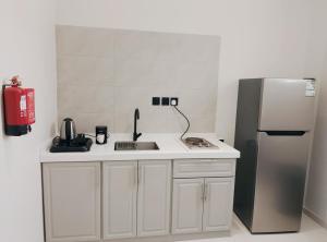 a kitchen with a sink and a refrigerator at شاليهات المروان لبيوت العطلات - AL-Marwan for Holiday Homes in Ash Shafa