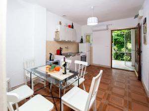 a kitchen with a glass table and white chairs at Apartments Mia Patria in Ulcinj