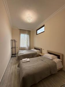 a bedroom with three beds and a window at Guest House MD in Halidzor