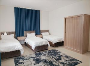 two beds in a room with two rugs at شاليهات المروان لبيوت العطلات - AL-Marwan for Holiday Homes in Ash Shafa