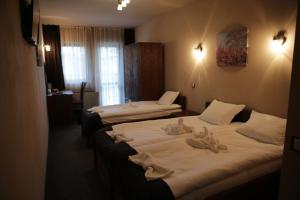 two beds in a hotel room with towels on them at Family hotel Valchanovata Kashta in Fotinovo