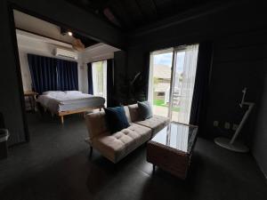 a living room with a couch and a bed and a window at MOTOBU Ocean Private Villa in Motobu