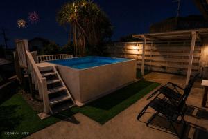 a hot tub with a ladder next to a patio at night at MOTOBU Ocean Private Villa in Motobu
