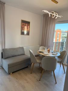 a living room with a table and a couch at Apartament Cysterski Pelplin in Pelplin