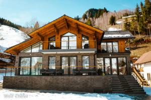a house on a hill with snow at Wolf Chalet - Moieciu de Sus in Moieciu de Sus