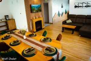 a living room with a table and a couch at Wolf Chalet - Moieciu de Sus in Moieciu de Sus