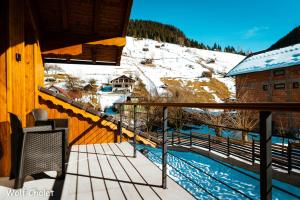 a balcony of a cabin with a snow covered mountain at Wolf Chalet - Moieciu de Sus in Moieciu de Sus