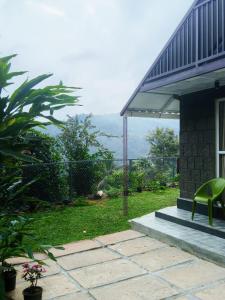 a house with a green chair sitting on a patio at Mount Homestay in Nedukandam