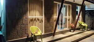 two green chairs sitting on the porch of a building at Mount Homestay in Nedukandam