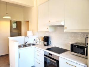 a kitchen with white cabinets and a sink and a stove at PHILIPPOS 2 in Diaporos