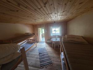 a room with several bunk beds and a table at Ofvansjö Gård , Enkel stuga för övernattning på ett fd militärområde in Sandviken