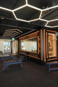 a gym with several benches in a room with lights at Arados Resort in Bdibbā