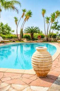 a large vase sitting next to a swimming pool at Christoforos Apartments in Lourdata
