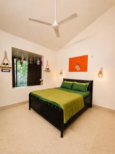 a bedroom with a bed with green sheets and a ceiling at Coconut Sky 2Bhk Penthouse Baga in Baga +19 photos