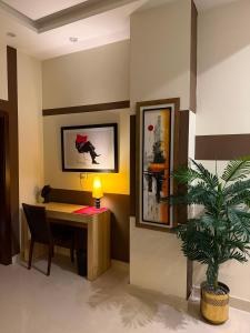 a office with a desk and a potted plant at Private & Serene Golf View Apt Phase 7 in Rawalpindi