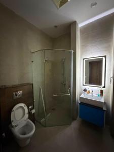 a bathroom with a shower and a toilet and a sink at Private & Serene Golf View Apt Phase 7 in Rawalpindi +13 photos