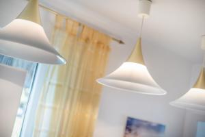 two white lights hanging from a ceiling next to a window at Henning in Keitum