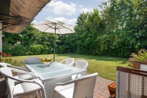 a table and chairs with an umbrella on a patio at Henning in Keitum +20 photos