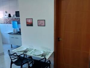 a kitchen with a table and two chairs and a door at Parque Ecológico - Studio 3 - Térreo in Indaiatuba