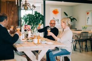 a group of people sitting around a table drinking wine at Svabesholms Kungsgårds B&B och Pensionat Stenshuvud in Kivik