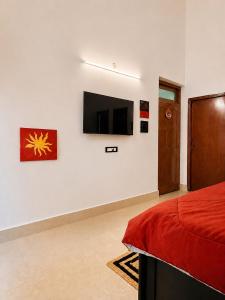 a bedroom with a flat screen tv on a wall at Coconut Sky 2Bhk Penthouse Baga in Baga