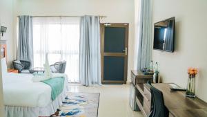 a hotel room with a bed and a desk and a television at The Ace Hotel in Lusaka
