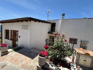 a white house with flower pots in front of it at Agrialloggio Supramonte in Barisciano