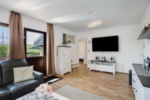 a living room with a couch and a television at Ferienhaus Bianca in Meschede