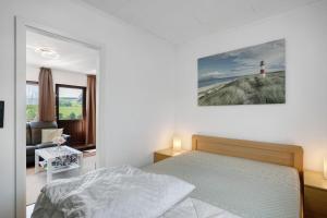 a white bedroom with a bed and a lighthouse at Ferienhaus Bianca in Meschede