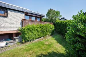 a backyard of a house with a hedge at Ferienhaus Bianca in Meschede